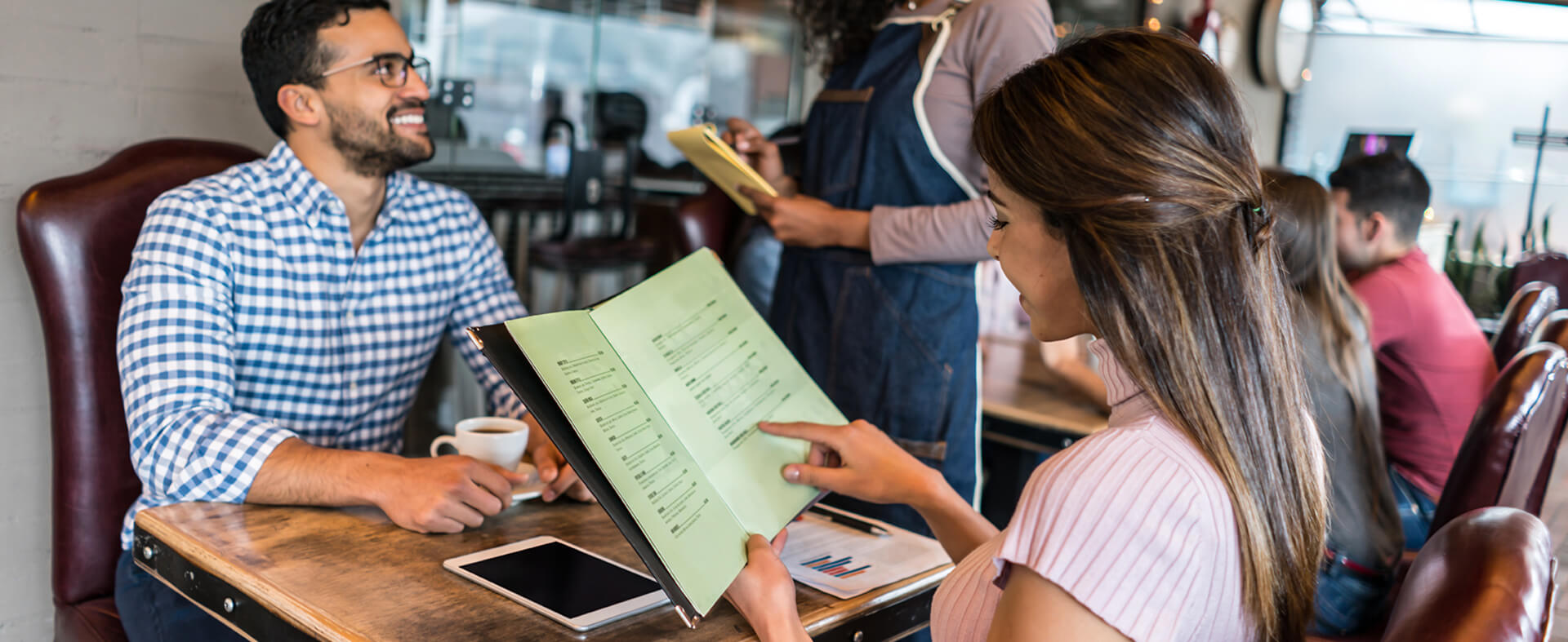 Patrons using physical menus over QR codes.
