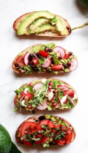 Source: Yummy Mummy Kitchen Stack of four different avocado toast images.