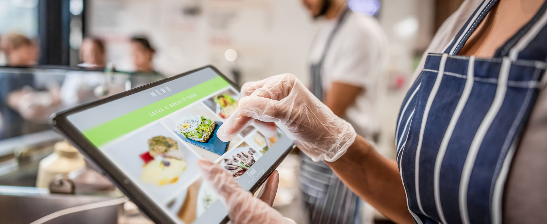 Restaurant server using technology to select a recipe to prepare for a customer.
