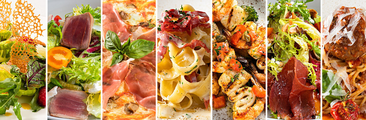 Horizontal image of a variety food dishes in close-up, straight-on view from meatballs to pasta, shrimp and salads.