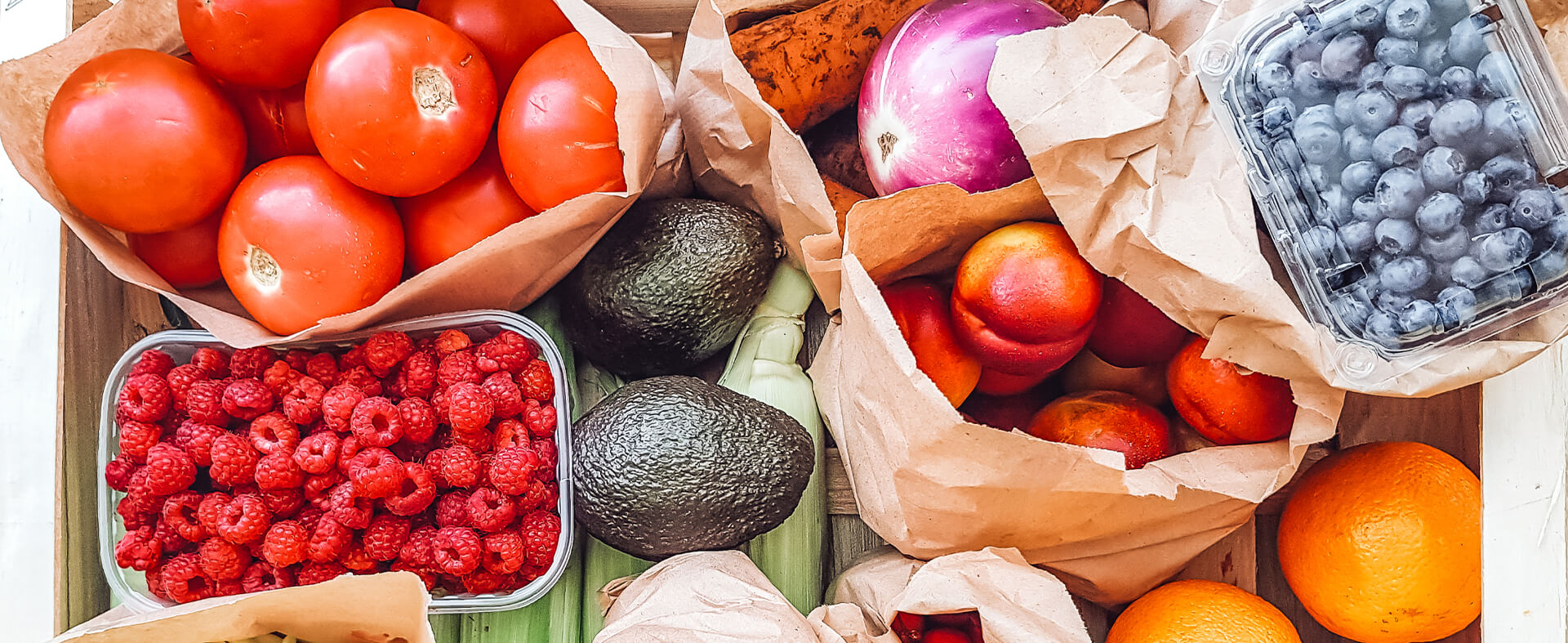 Collection of fresh fruits in bags or plastic containers.