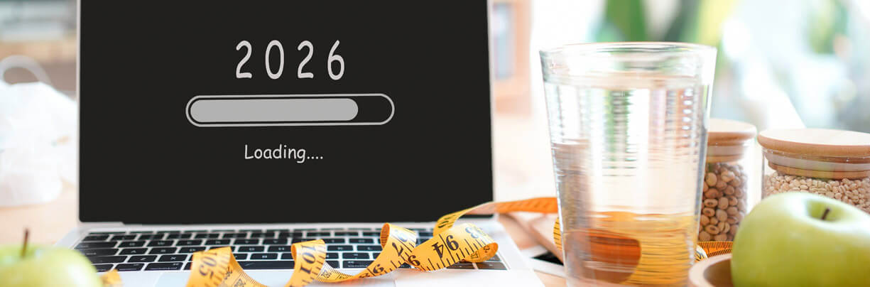 AI-generated image of a laptop with the year 2026 displayed above a loading screen surrounded by a measuring tape, water and fruit.