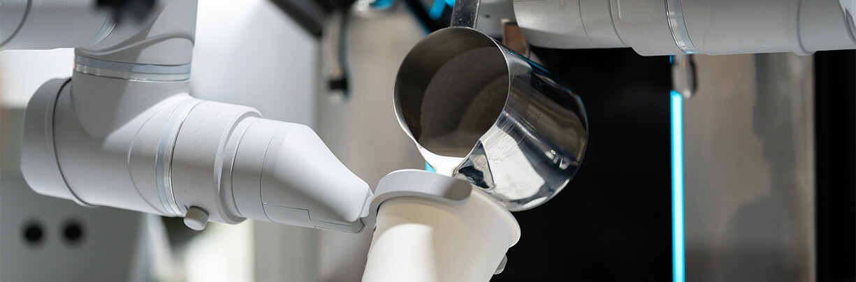 Close-up of a robotic arm making a coffee drink in a quick-service restaurant.