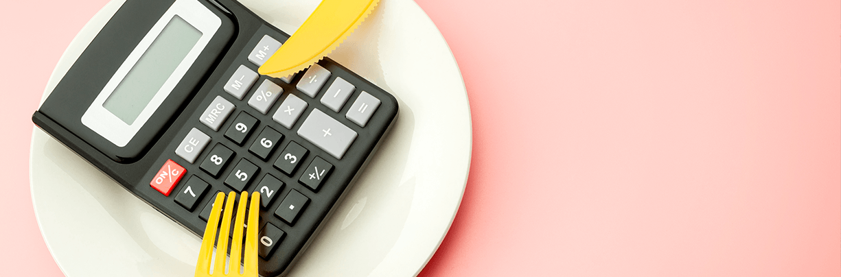Doing the margin math: A calculator on a plate with a fork and a knife.